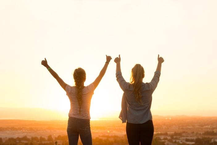 two women raising thier hands